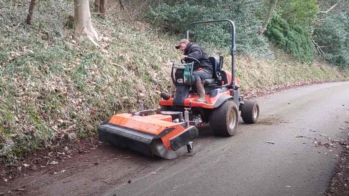 Kubota F-Series outfront mower fitted with a Kersten sweeper on a paved path