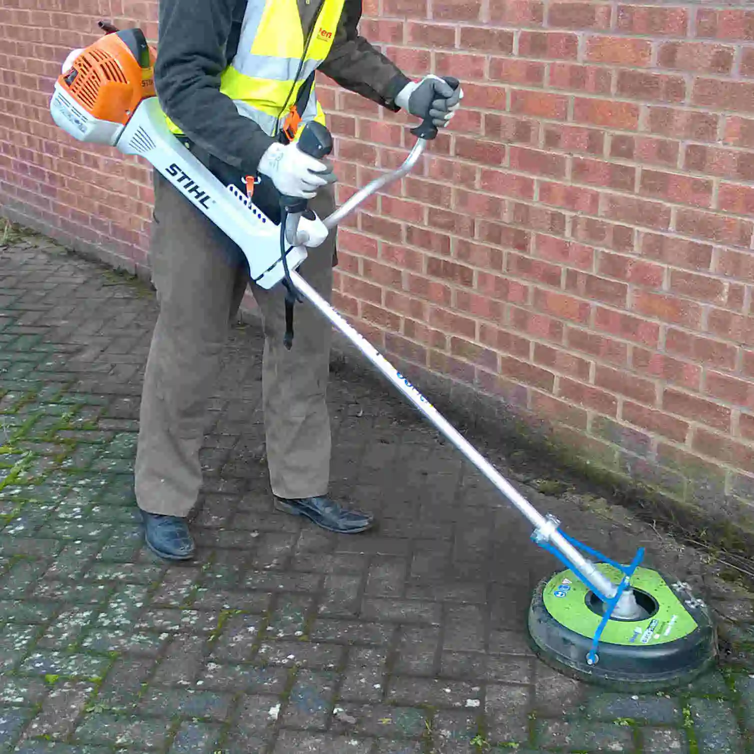 WeedGo QuickPro brushcutter weed-brush kit working along a hard-surface edge